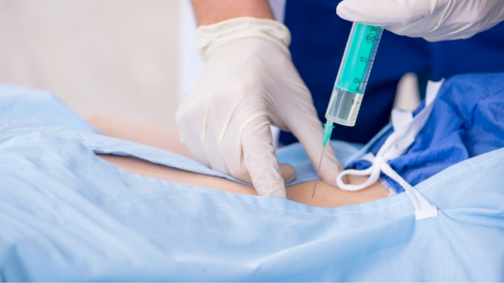 Um médico realizando uma infiltração na coluna.
